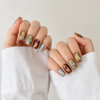 Patina Relic bronze manicure on two softly curled hands