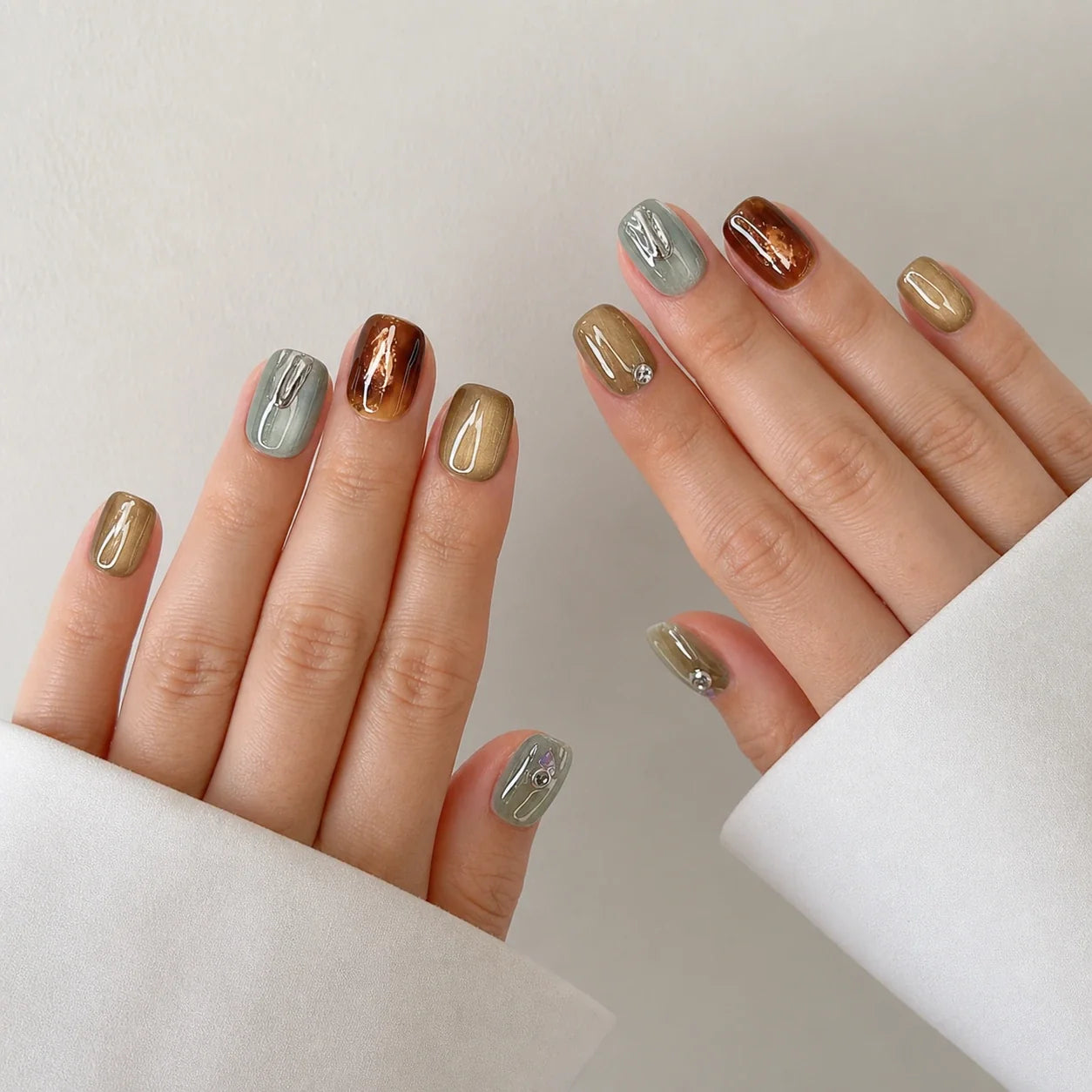 Patina Relic short square press-on nails on two open hands