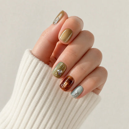 Patina Relic amber chrome manicure on one curled hand