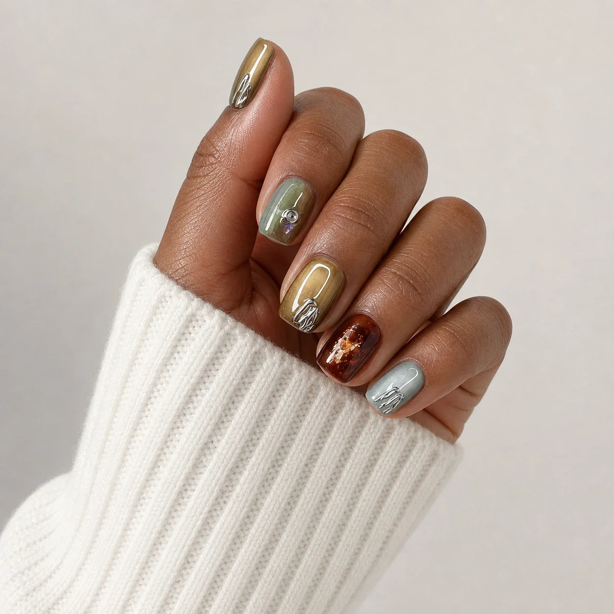Patina Relic cat-eye manicure on one medium-brown hand