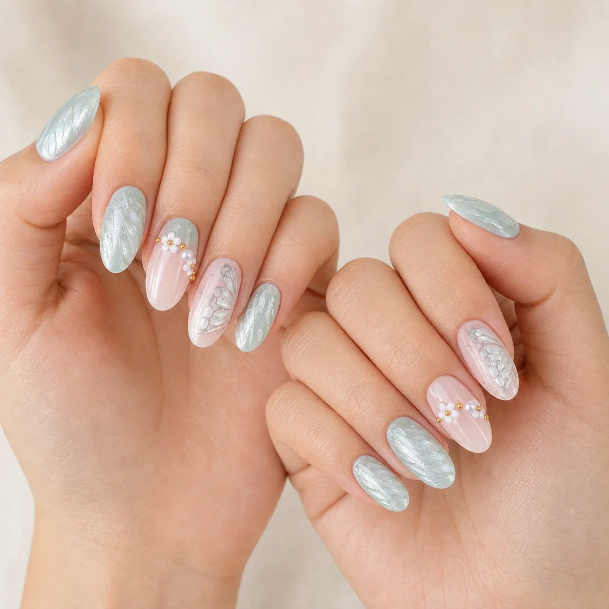Pearlwing Garden seafoam medium almond press-on nails on two softly curled hands