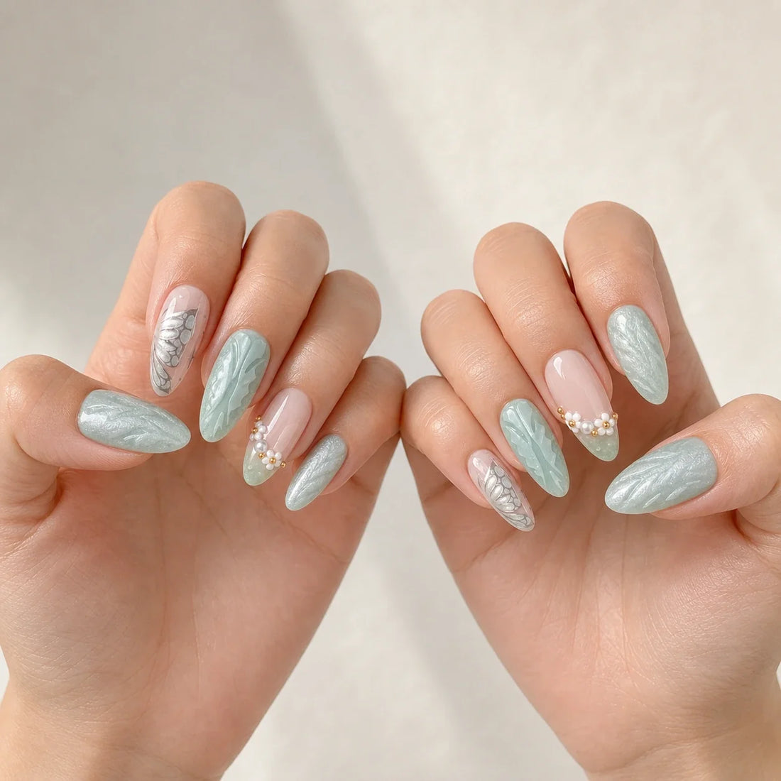 Pearlwing Garden seafoam medium almond press-on nails on two open hands