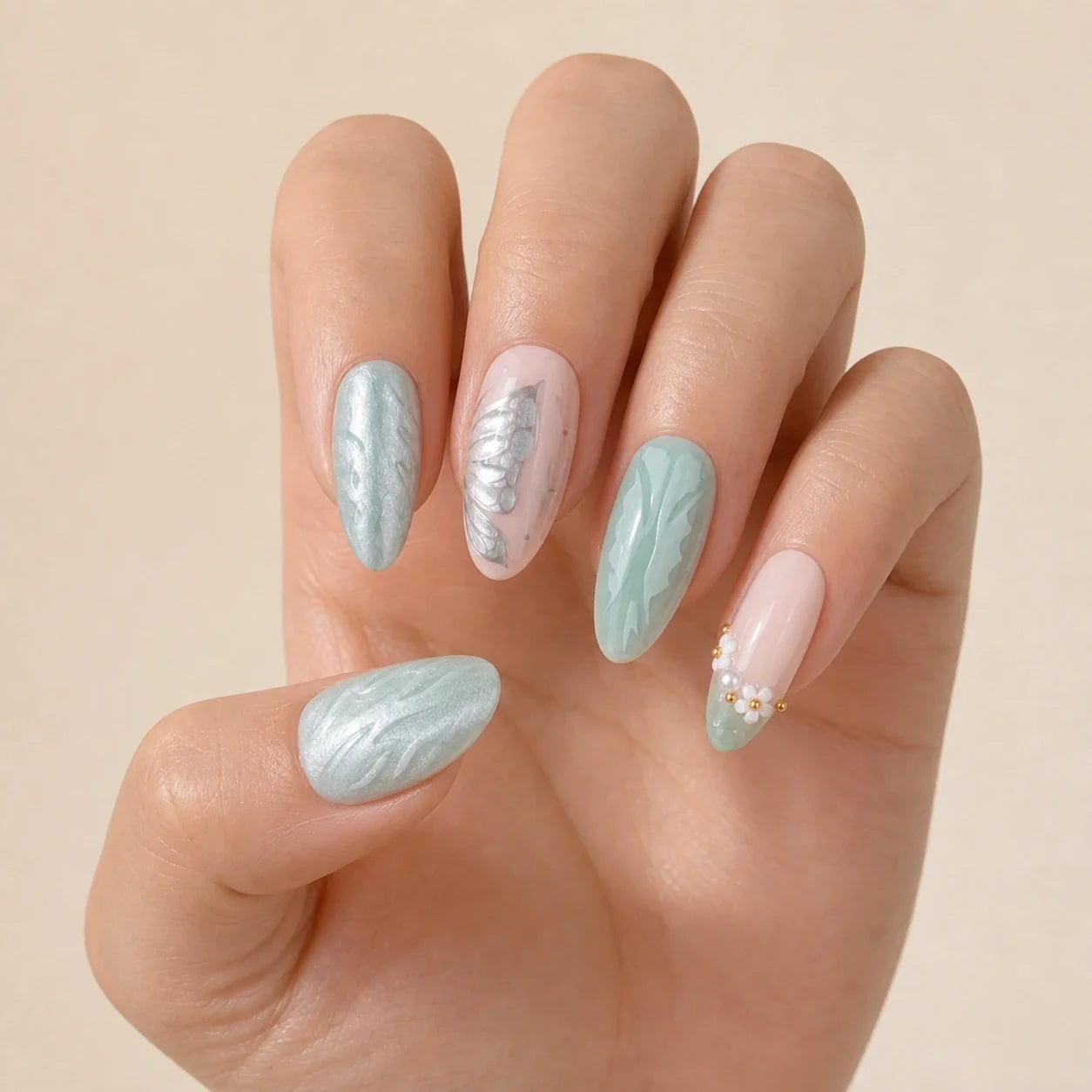 Pearlwing Garden seafoam medium almond press-on nails on one open hand