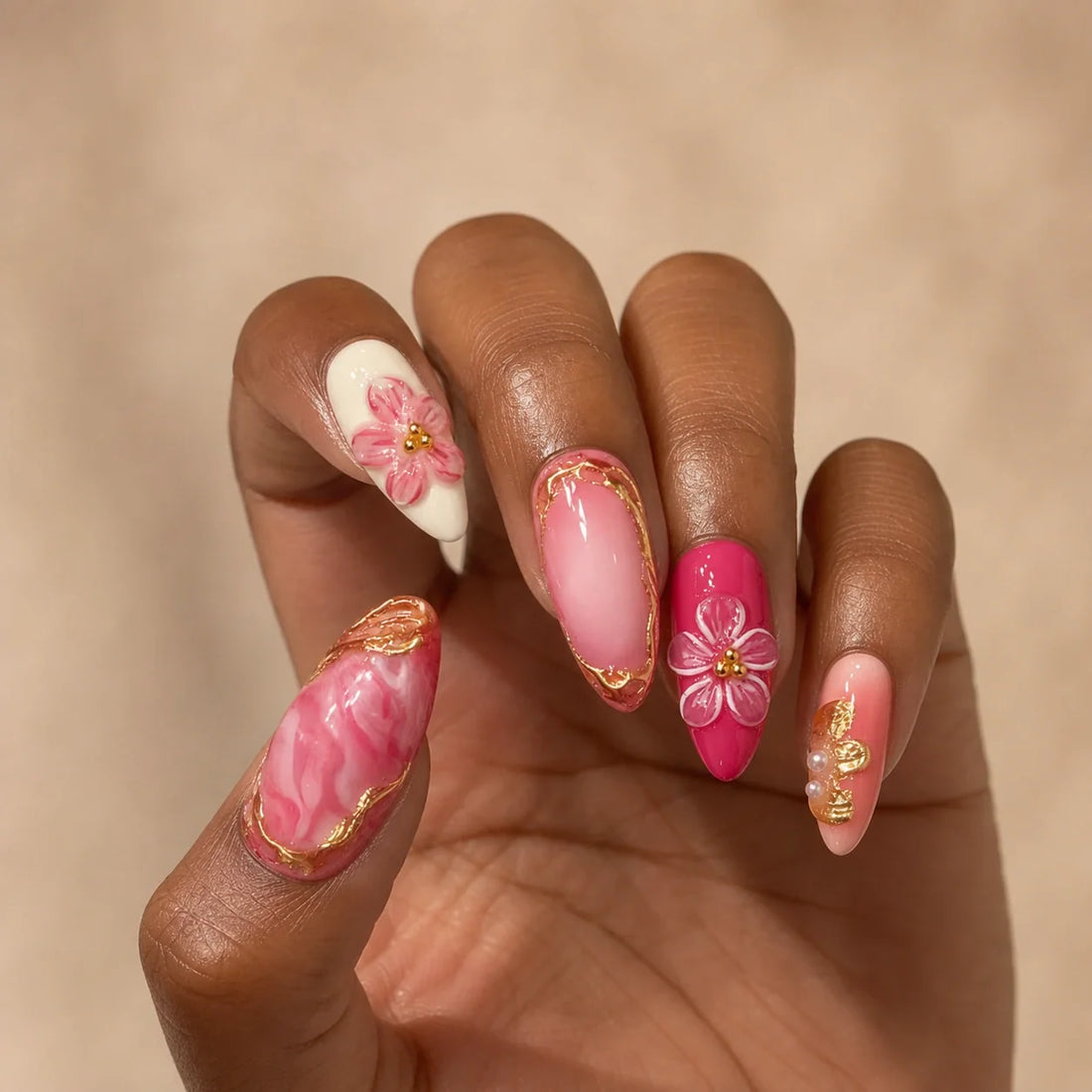 Petal Regalia gold bow manicure on one medium-brown hand