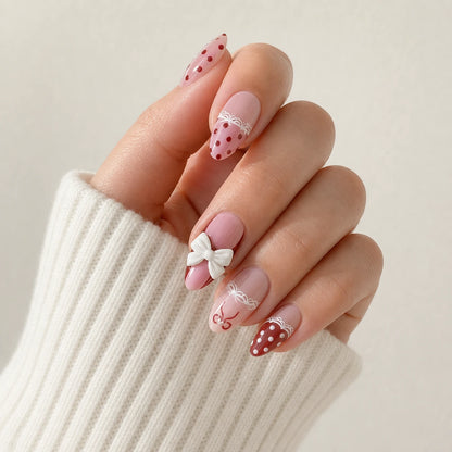 Polka Pirouette pink bow medium almond press-on nails on one softly curled hand, previous version