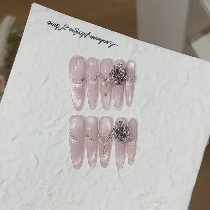 Lustre Locket product video showing blush cat-eye press-on nails with chains and smoky jewels