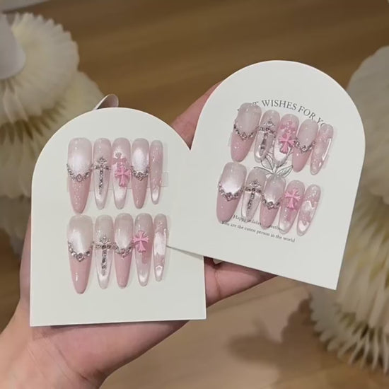 Blush Benediction product video showing blush cat-eye press-on nails with chains and crystal crosses