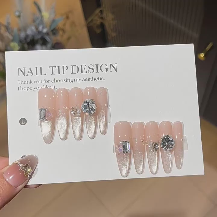 Moonlit Facet product video showing nude pink cat-eye press-on nails with silver crystal details