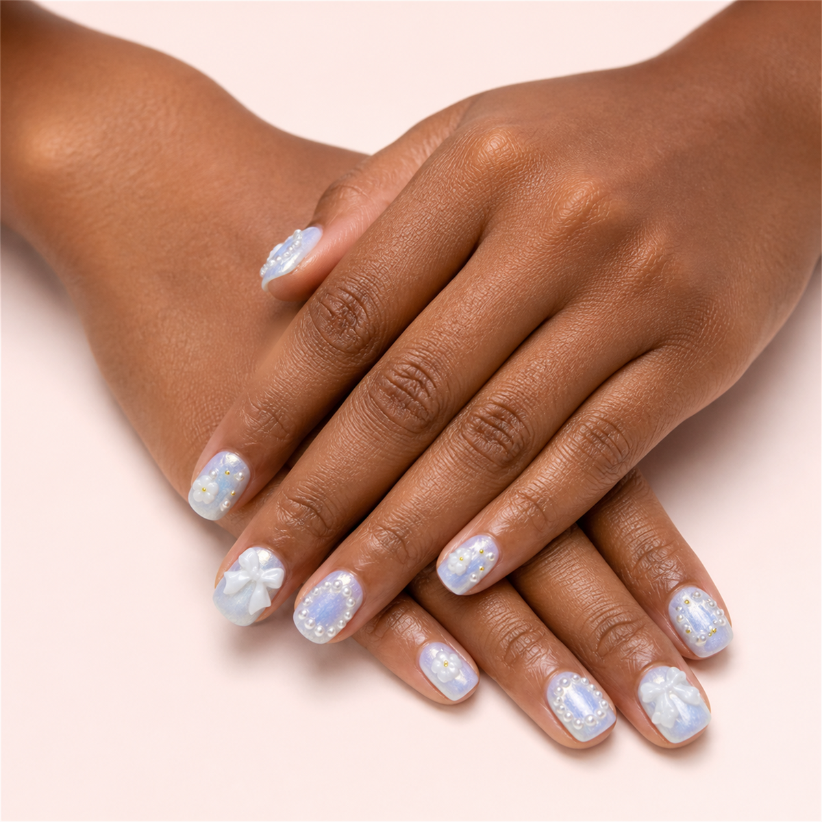 Ribbon Frost short square press-on nails in a two-hand soft-pose view.