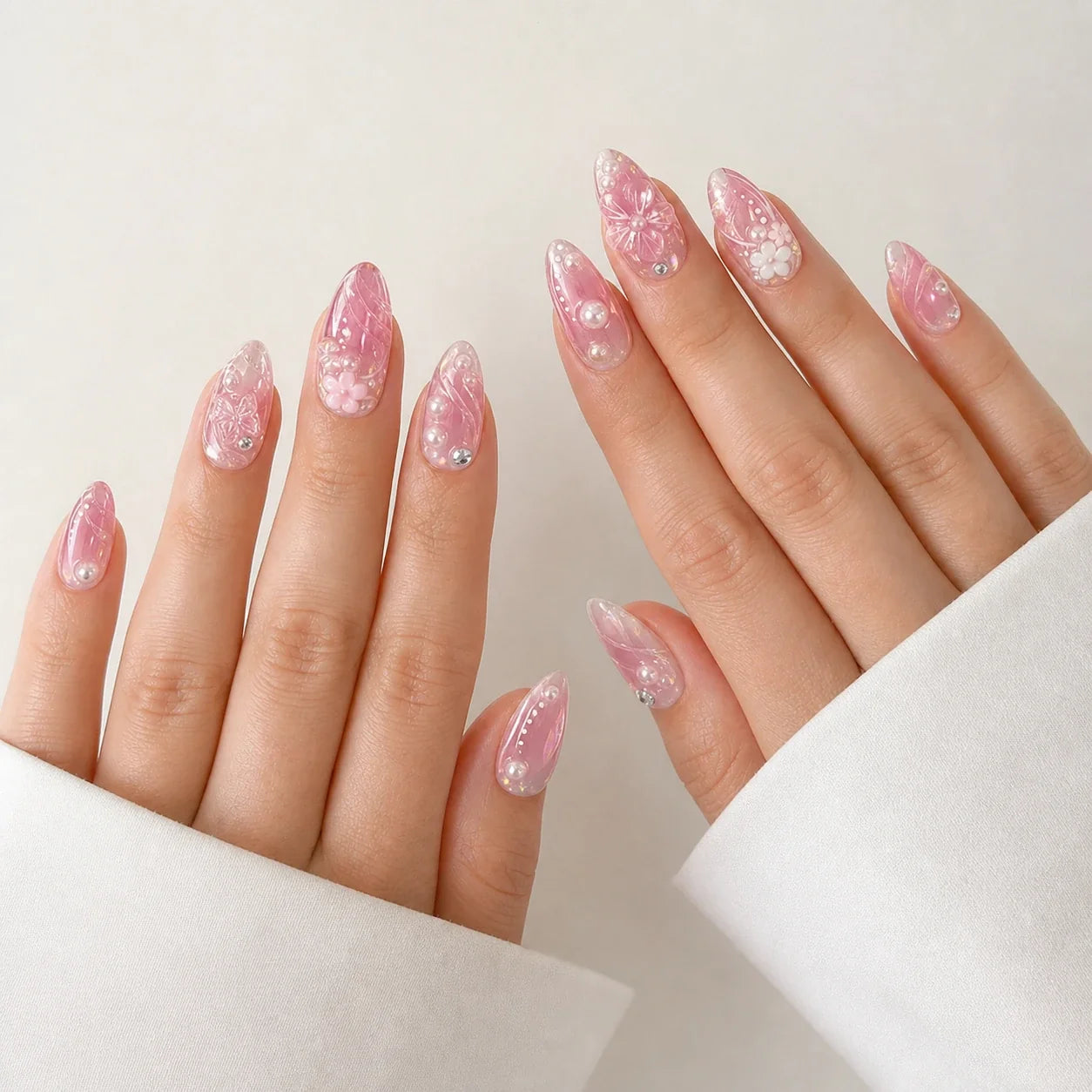 Roselight Terrarium pink floral medium almond press-on nails on two open hands