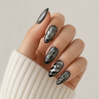 Silver Seance cross heart and chain manicure on one curled hand