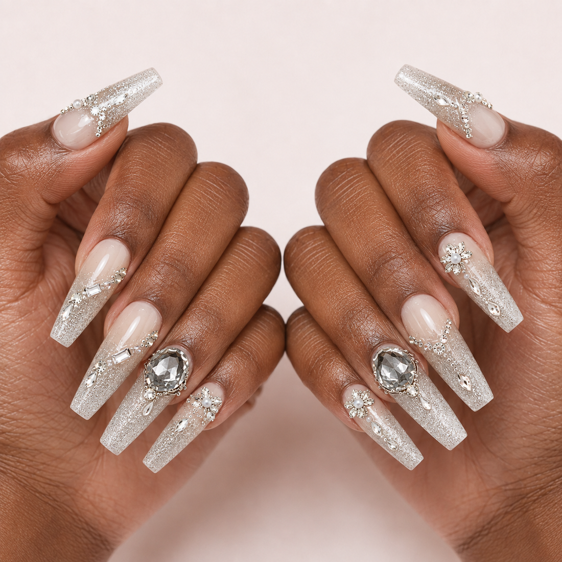 Two medium-brown hands presenting Smoky Diadem long coffin press-on nails with silver glitter and crystal accents