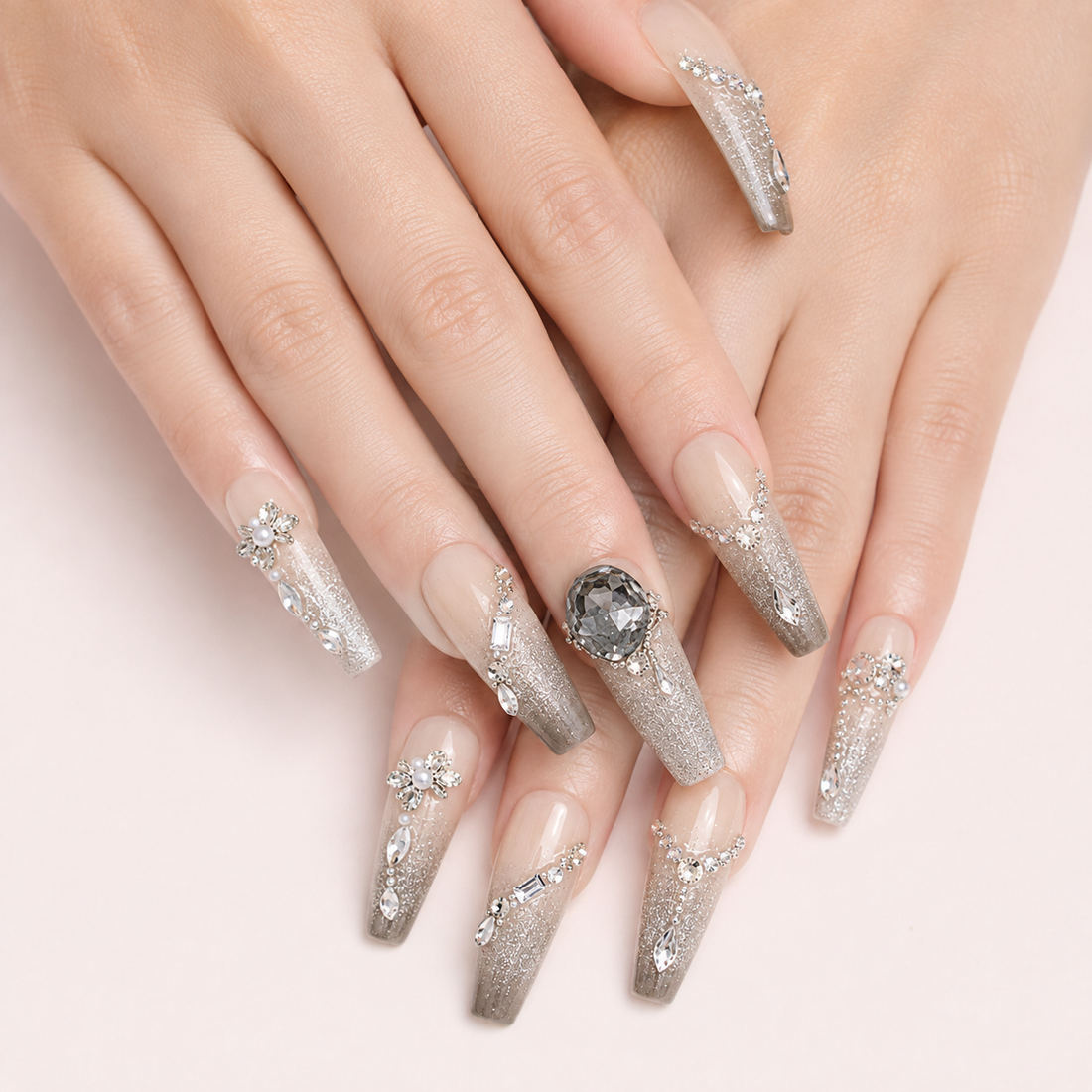 Two light-skin hands wearing Smoky Diadem long coffin press-on nails with silver glitter and crystal details
