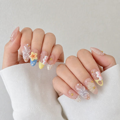 Sunlit Lagoon floral and shell press-on manicure on two softly curled hands