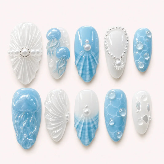 Tidal Cameo medium almond press-on nails in blue and milky white with 3D ocean details