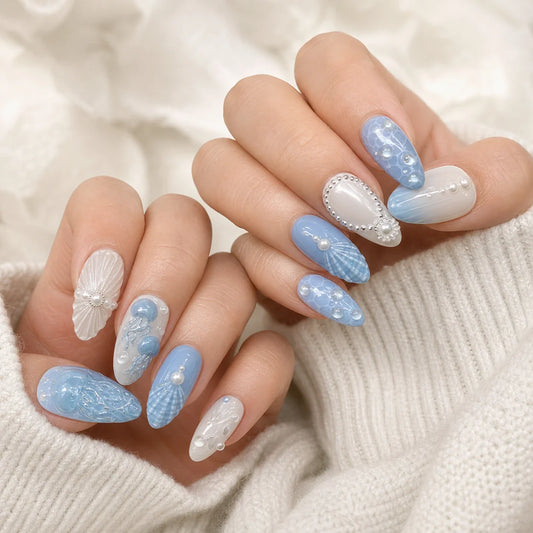 Tidal Cameo blue and white ocean press-on manicure on two softly curled hands
