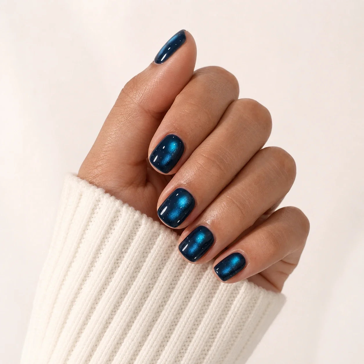 Twin Nebula cat eye manicure on one medium-brown hand