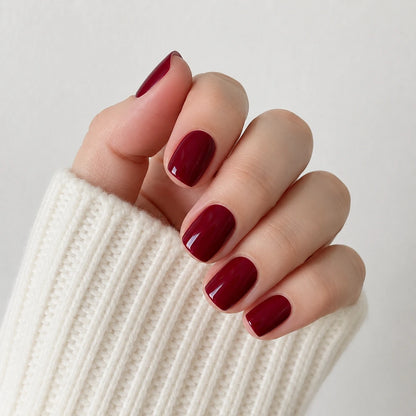 Velvet Merlot short square wine red press-on nails in a close-up curled hand view