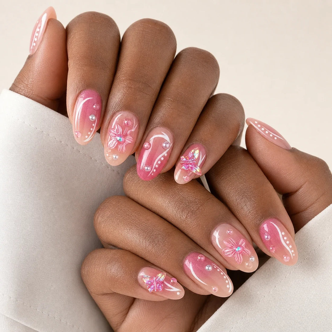 Winglight pink jelly and butterfly manicure on two medium-brown hands