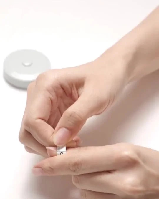 Measuring a natural nail with a soft measuring tape across the widest curve