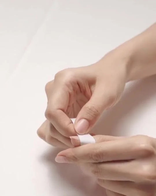 Measuring a natural nail with a paper strip and ruler